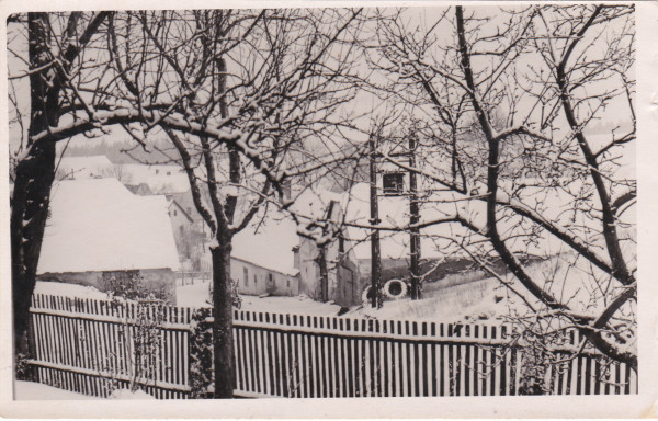 Kosov v zimě. Snímek zachycuje v levé části obecní kovárnu. Rok 1955, začátky kolektivizace.